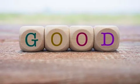 Good word written on cube shape wooden blocks on wooden table.  Stock Photos