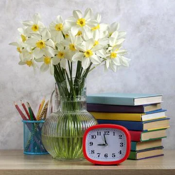 Goodbye, school! A composition with daffodils, textbooks and an alarm clock. Foto stock