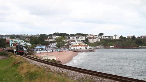 Goodrington Sands, Devon: Steam train Braveheart along railway line Stock Footage 115573885