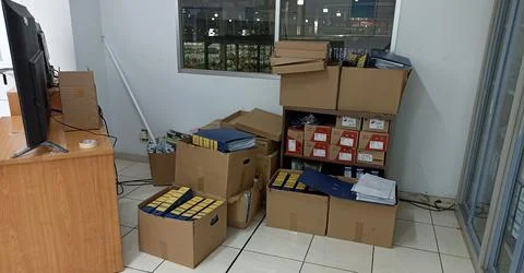 Goods and documents in boxes are lying irregularly in the office Stock Photos