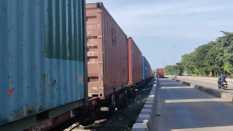  goods train running and a container lorry driving down the road. Stock Footage 232750205