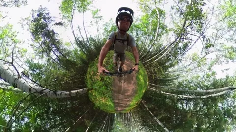 Goofy looking 360 type tiny-planet clip of a man riding a mountain bike  Stock Footage 248564021
