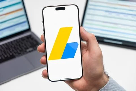 Google Adsense logo on the screen of mobile phone in mans hand Stock Photos