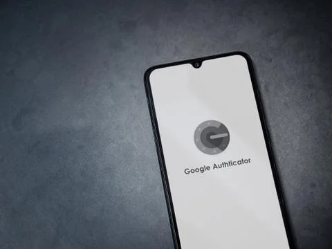Google Authenticator app launch screen with logo on the display of a black mo Stock Photos