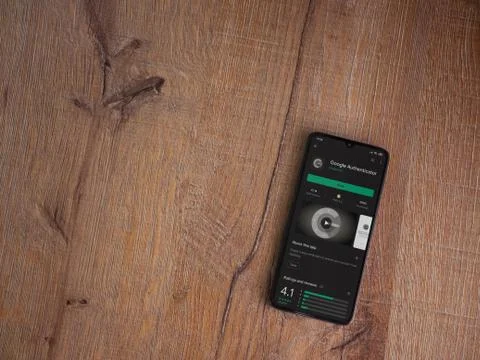 Google Authenticator app play store page on the display of a black mobile sma Stock Photos