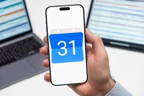 Google Calendar logo on the screen of mobile phone in mans hand Stock Photos