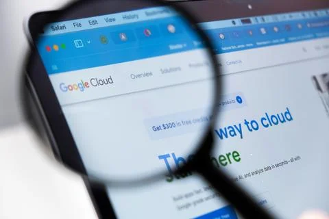 Google Cloud logo on the screen of laptop through magnifying glass Stock Photos