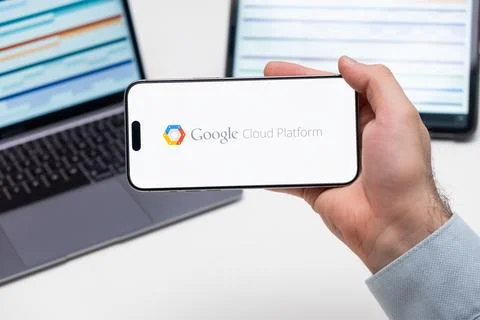 Google Cloud Platform logo of app on the screen of mobile phone held by man Stock Photos