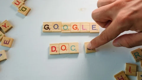 Google Docs spelled with wooden tiles letters. Off white background. Flat Stock Footage 104411736