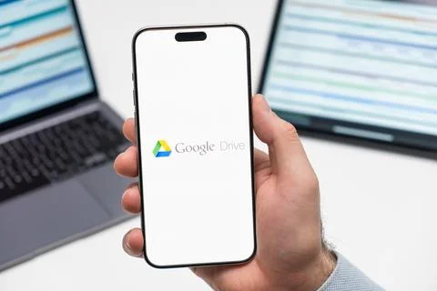 Google Drive logo on the screen of mobile phone in mans hand Stock Photos