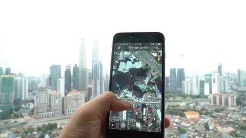 A Google Earth user using the app in his smartphone Stock Footage 69222159