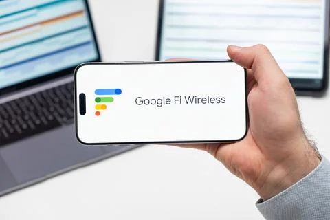 Google Fi Wireless logo of app on the screen of mobile phone held by man in Stock Photos