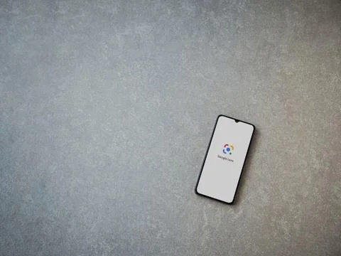 Google Lens app launch screen with logo on the display of a black mobile smar Stock Photos