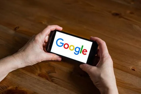 Google logo sign application screen on mobile phone online retail service, hands 库存照片