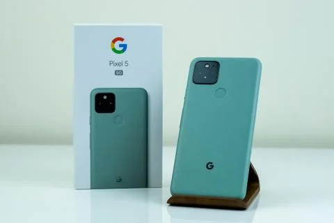 Google Pixel 5 in Sorta Sage color next to its box. Stock Photos