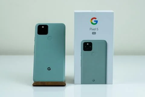 Google Pixel 5 in Sorta Sage color next to its box. Stock Photos