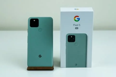 Google Pixel 5 in Sorta Sage color next to its box. Stock Photos