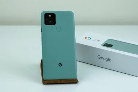 Google Pixel 5 in Sorta Sage color next to its box. Stock Photos
