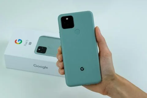 Google Pixel 5 in Sorta Sage color next to its box. Stock Photos