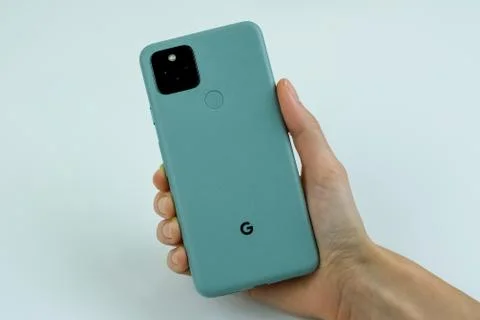 Google Pixel 5 in Sorta Sage color next to its box. Stock Photos