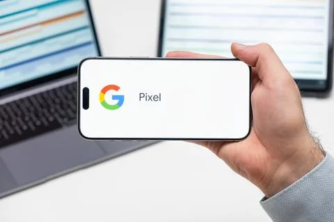Google Pixel logo of app on the screen of mobile phone held by man in front of Foto stock