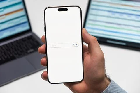 Google Search logo on the screen of mobile phone in mans hand Stock Photos