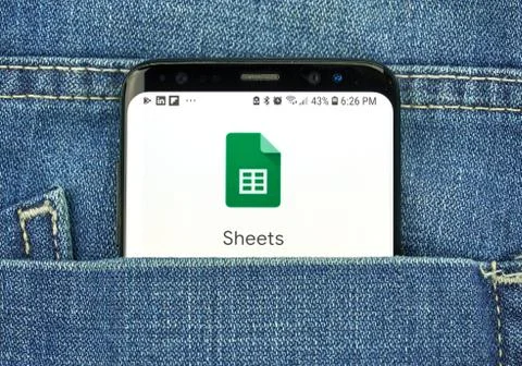 Google Sheets on a phone screen in a pocket Stock Photos