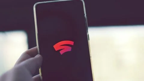 Google Stadia logo on smartphone cloud gaming streaming service Stock Photos