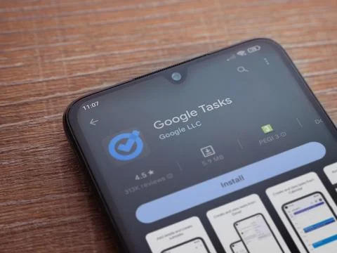 Google Task app play store page on smartphone on wooden background Stock Photos
