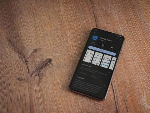 Google Task app play store page on smartphone on wooden background Stock Photos