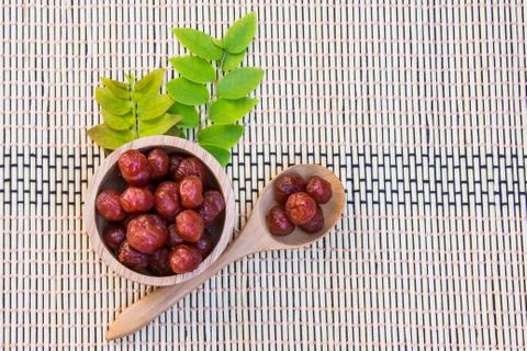 Gooseberry in syrup put in wood bowl and spoon on bamboo wicker, Mayom chueam Stock Photos