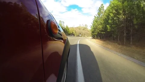 GoPro mounted on side of car on a winding road with trees in Northern California Stock Footage 78164259