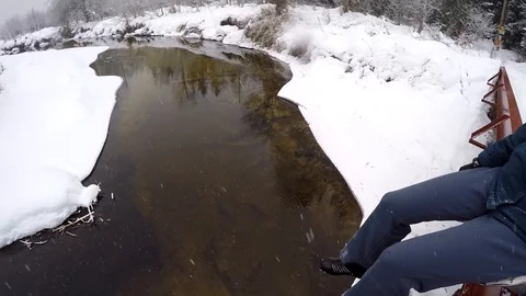 GoPro Pan of legs dangling over river Stock Footage 86450690