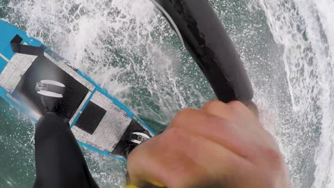 GoPro shot of surfer surfing while holding onto rope behind jet ski Stock Footage 163294055