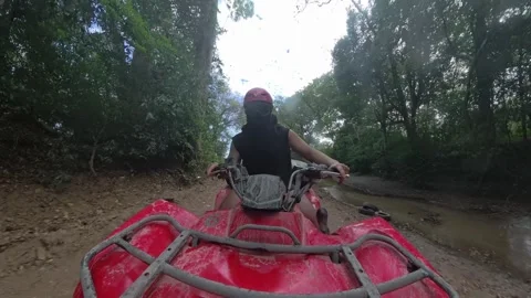 GoPro view of ATV driving fast on jungle trail splashing water Stock Footage 311089846