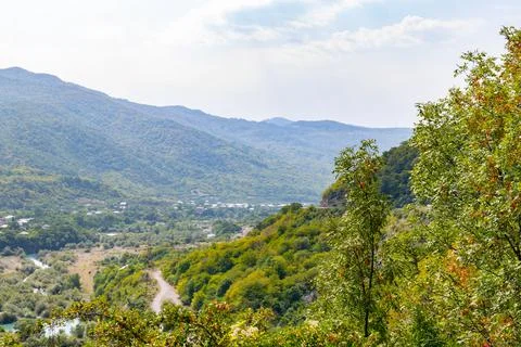 Gorge between mountains green trees blue sky Stock Photos
