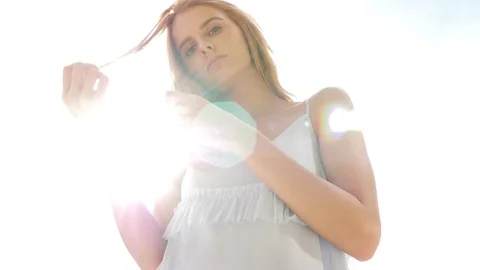 Gorgeous attractive redhead model posing to the camera against the sun and sun Stock Footage 93139884