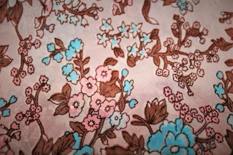 Gorgeous background image of a light beige fabric with a pattern of flowers. Stock Photos