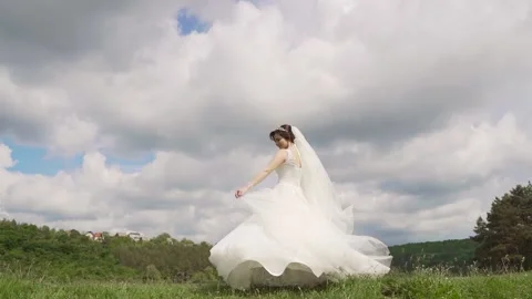 Gorgeous bride dancing against the background of a clouds. Slow motion Video stock 233525098