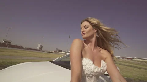 Gorgeous bride falls back onto her luxury car Vídeos de archivo 61057282