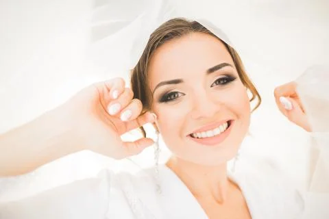 Gorgeous bride in robe posing and preparing for the wedding ceremony face in a Foto stock