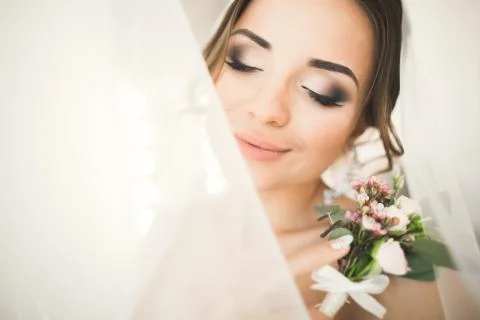 Gorgeous bride in robe posing and preparing for the wedding ceremony face in a Stock Photos