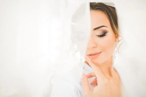 Gorgeous bride in robe posing and preparing for the wedding ceremony face in a Foto stock