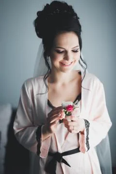Gorgeous bride in robe posing and preparing for the wedding ceremony face in a Stock Photos
