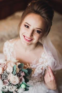 Gorgeous bride in robe posing and preparing for the wedding ceremony face in a Stock Photos