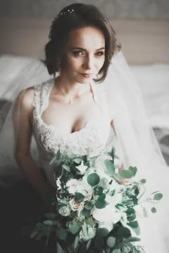 Gorgeous bride in robe posing and preparing for the wedding ceremony face in a Stock Photos