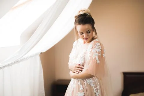 Gorgeous bride in robe posing and preparing for the wedding ceremony face in a Stock Photos