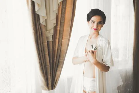 Gorgeous bride in robe posing and preparing for the wedding ceremony face in a Stock Photos