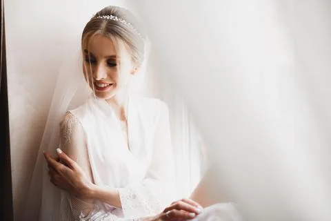Gorgeous bride in robe posing and preparing for the wedding ceremony face in a Stock Photos