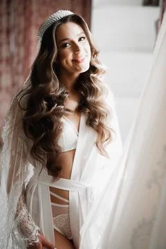 Gorgeous bride in robe posing and preparing for the wedding ceremony face in a Stock Photos
